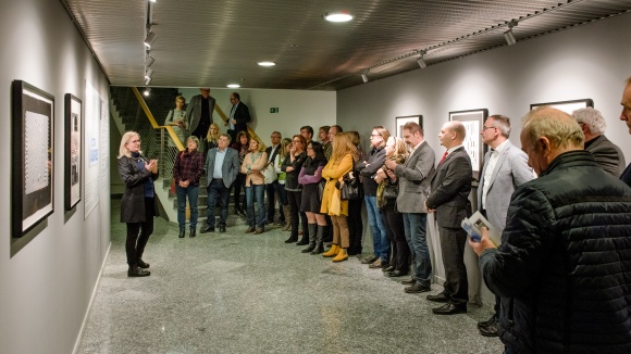 Personengruppe in einem Ausstellungsraum mit Gem&auml;lden